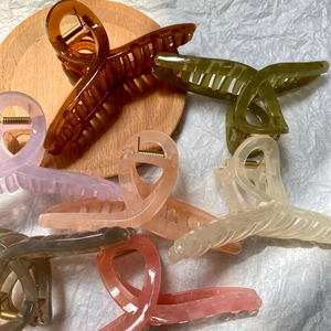 Close-up of matte jelly colored oversized hair claw clips in various candy tones