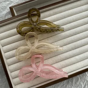 Lot de trois pinces à cheveux translucides en forme de nœud en vert, crème et rose