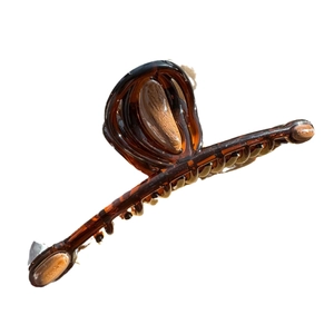 Elegant amber tortoiseshell hair claw clip with a glossy finish and long curved design