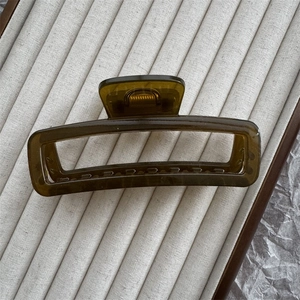 Macro view of dark olive green rectangular hair claw clip with strong metal spring