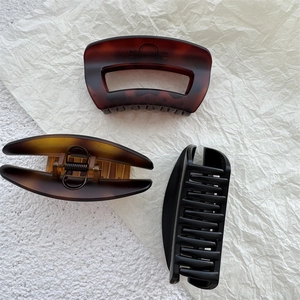 Three large tortoiseshell and matte black shark hair claws with strong metal springs
