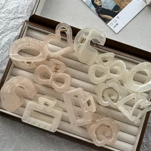 Set di mollette per capelli geometriche rosa pastello e bianco in una scatola da esposizione