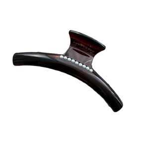 Elegant tortoiseshell resin hair claw clip with white pearl accents on white background