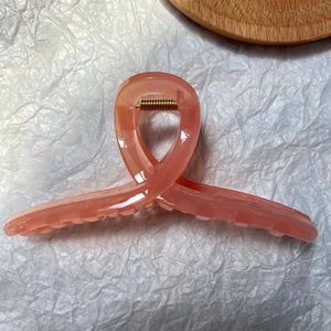 Close-up of a large pink matte jelly hair claw clip with a strong gold metal spring