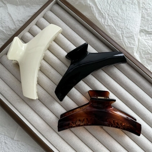 Trois grandes pinces à cheveux minimalistes en blanc crème, noir et motif écaille