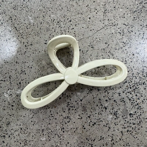 Detail view of the beige bow-shaped hair claw with strong interlocking teeth for firm grip