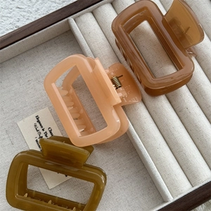 Lot de trois pinces à cheveux géométriques évidées en résine marron, rose et vert