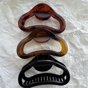 Three minimalist matte hollow claw clips in leopard, amber, and frosted black finishes