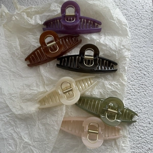 Detailed set of large jelly-colored hair claws in six elegant shades on textured paper