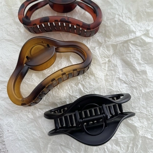 Close-up of matte claw clips in tortoise, light tea, and black colors for thick hair