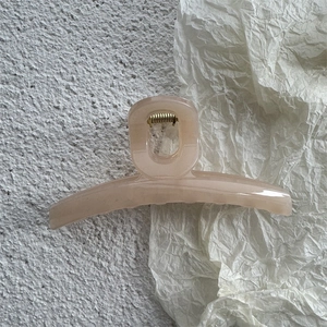 Detail of jelly colored hair claw clip with golden metal spring on aesthetic background