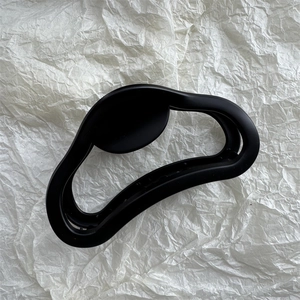 Macro detail of the matte black irregular wave shark hair clip with a smooth frosted finish