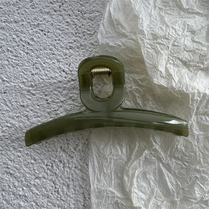 Close-up of translucent olive green jelly hair claw clip with durable metal spring