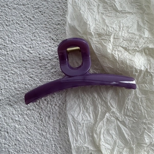 Detail view of large purple jelly hair claw clip with golden metal spring for women