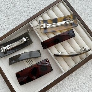 Square acetate spring hair clips set in tortoiseshell and amber for elegant ponytails