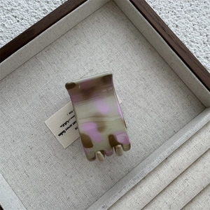 Détail de la pince à cheveux élégante avec motif marbré gris et lilas en acétate