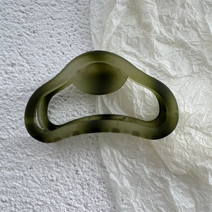 Dettaglio molletta per capelli verde militare opaca con design ad arco traforato