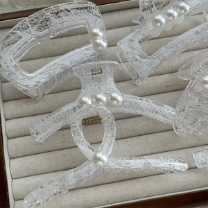 Détail de pinces à cheveux transparentes à motif dentelle avec perles d'imitation élégantes