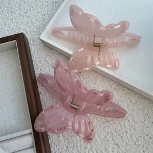 Close-up of pink translucent hair claws with ribbon details and metal spring