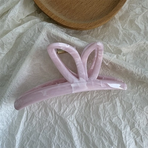 Macro detail of the durable pink marble butterfly hair claw clip with metal spring