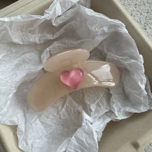 Close-up of a jelly beige hair claw clip with a 3D pink heart on aesthetic paper
