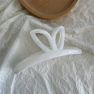 Detailed macro view of ink-white marble acetate hair claw with hollow rabbit ear handle