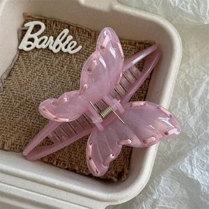 Close-up of pink marble acetate butterfly hair claw clip with woven ribbon detail
