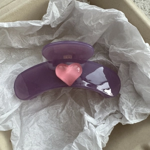 Close-up of a translucent purple heart hair claw clip with a pink resin heart detail