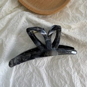 Macro view of large ink-pattern butterfly hair claw clip with golden metal spring details