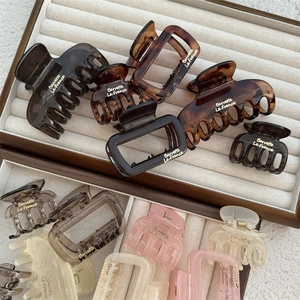 Minimalist square hair claw clips set in various colors with golden lettering in jewelry box