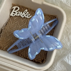 Detail of light blue butterfly claw clip with elegant ribbon weave and icy texture finish