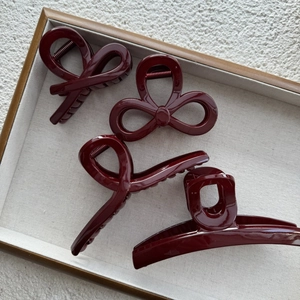 Set of four Ancla Red hair claws in various elegant shapes on a wooden display tray