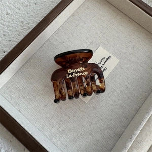 Close-up of amber tortoise shell hair claw clip with golden Barrette La France text