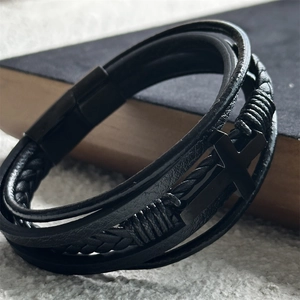 Macro shot of multi-layer black braided leather bracelet with stainless cross detail