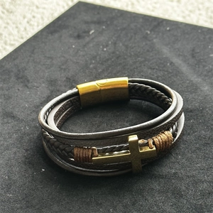 Detail view of multi-layer leather bracelet with golden cross and magnetic clasp closure