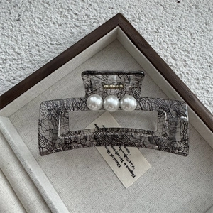 Détail de la pince à cheveux à motif dentelle ornée de trois perles nacrées élégantes