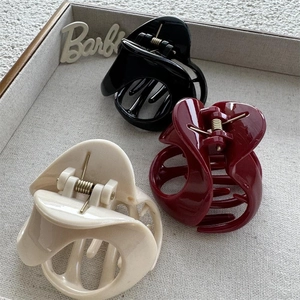 Three-piece set of glossy hollow triangle hair claws in black, cream, and wine red