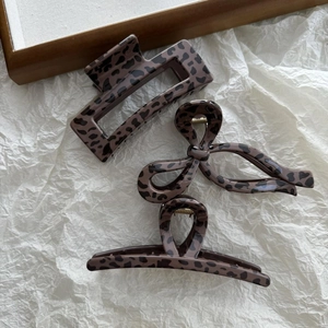 Macro view of leopard print hair claw clips in rectangular and bow-shaped resin designs