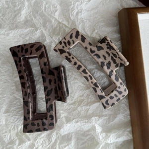 Close-up of square leopard print hair claws in dark brown and light beige resin