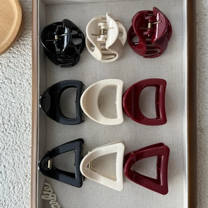 Set of 9 stylish triangle and geometric hair claws in black, cream, and burgundy colors