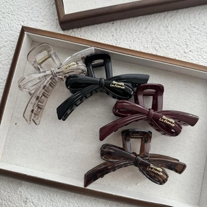Set of four elegant bow-shaped hair claws in translucent, black, red, and tortoiseshell finish