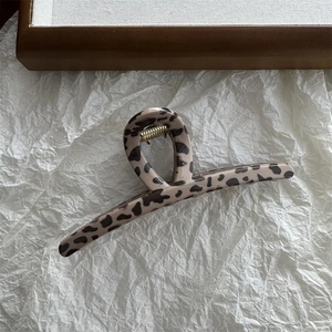 Close-up of leopard print hair claw clip with strong golden metal spring mechanism