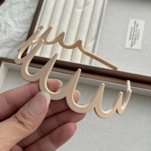 Vue macro d'une grande pince à cheveux beige ondulée avec finition mate et dents