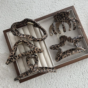 Detail showing five leopard print hair claws in various shapes on a jewelry tray