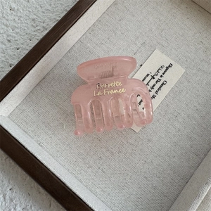 Detail of pink translucent acrylic hair claw with golden Barrette La France lettering