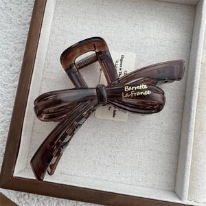 Elegant amber bow hair claw clip with gold lettering for women's hair styling