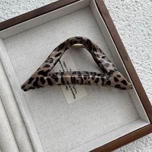 Detailed view of leopard print triangle hair claw with gold metal spring hinge