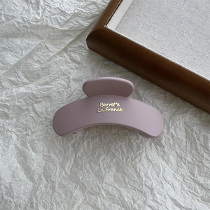 Close-up of matte purple cloud claw clip with elegant gold Barrette La France lettering