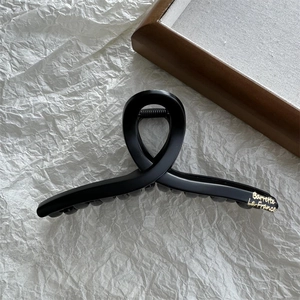 Detail of matte black French hair claw clip with golden Barrette La France text logo