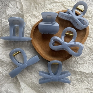Ensemble de pinces à cheveux et nœuds bleu sel de mer sur un plateau en bois chic